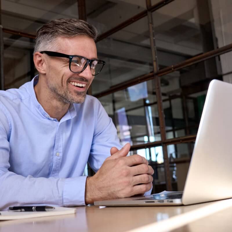 man smiling at laptop