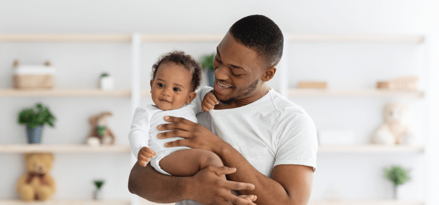 Man smiling while holding infant