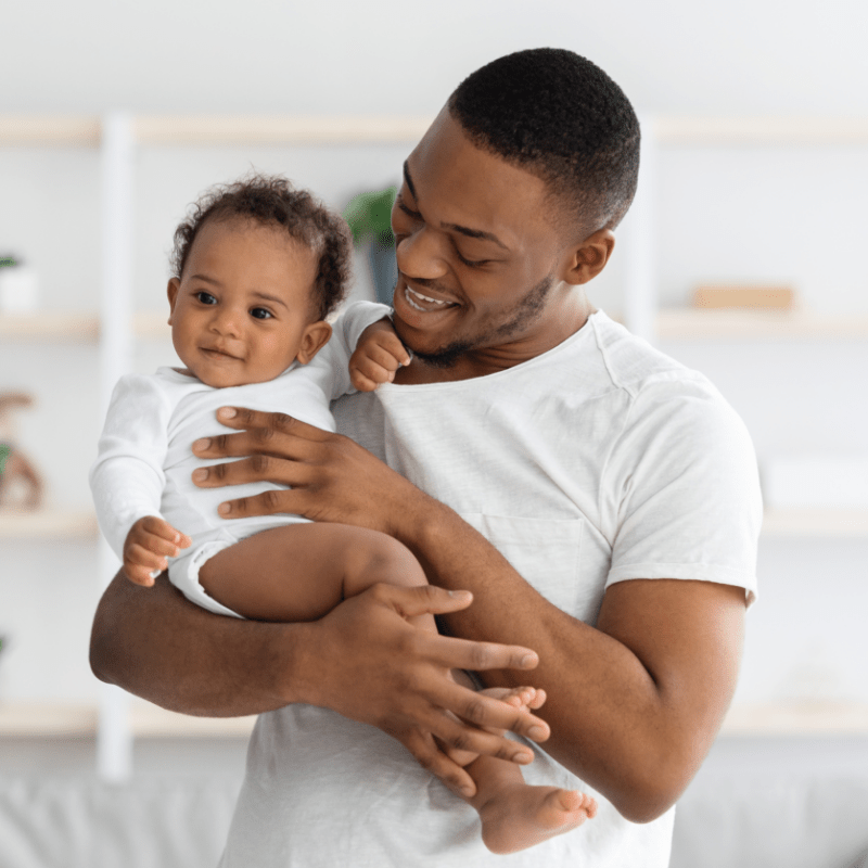 Man smiling while holding infant