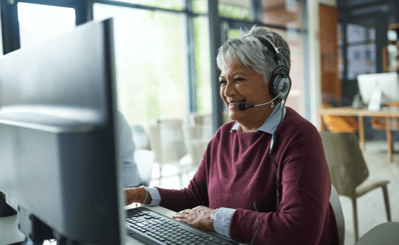 woman working on computer wearing headset